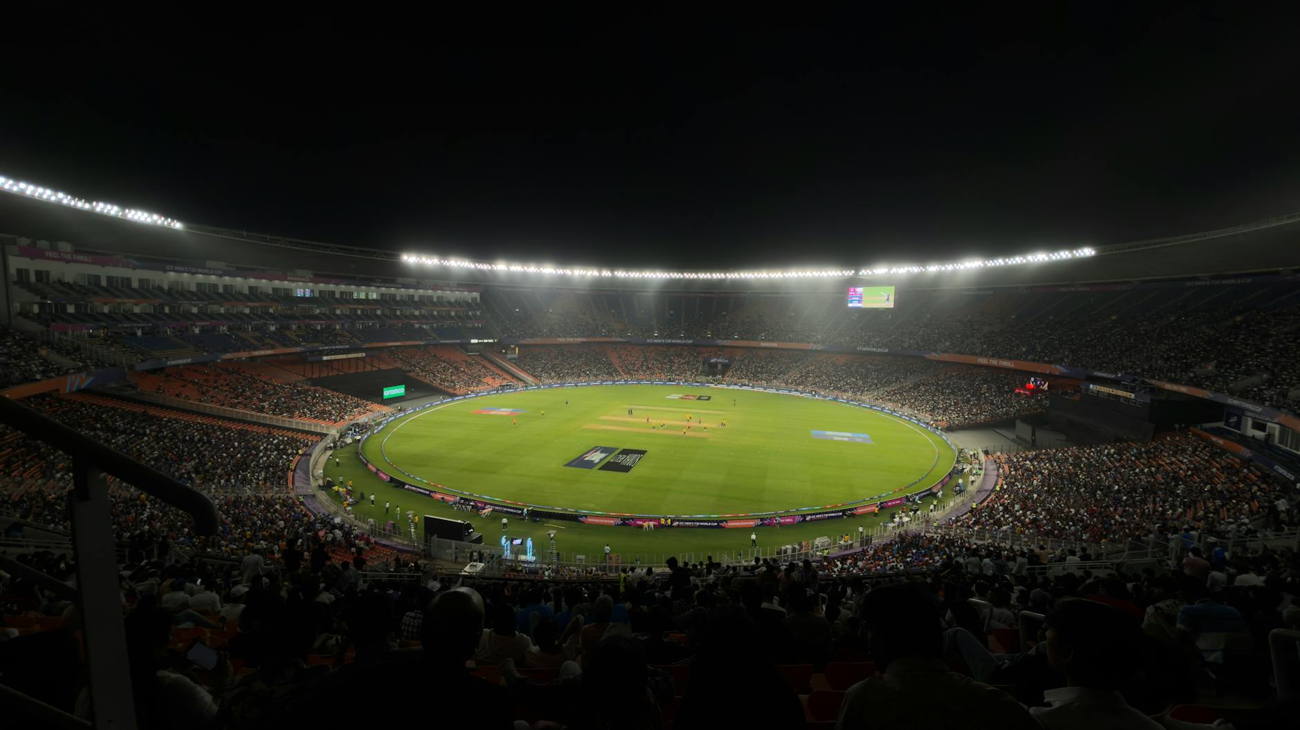 A captivating night cricket match with a large crowd at Narendra Modi Stadium in Ahmedabad, India.